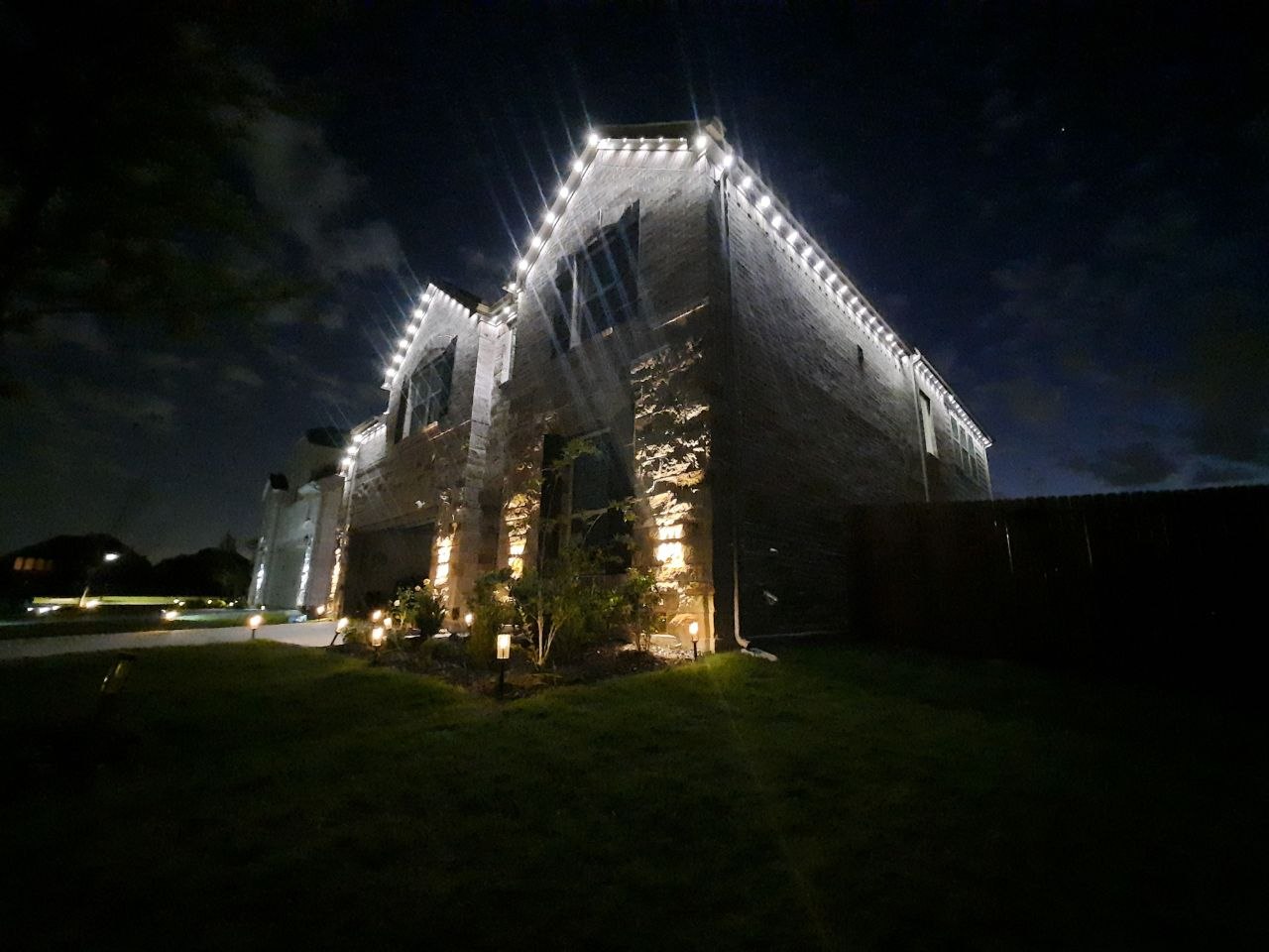 White roofline and landscape lighting on a two-story home